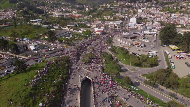 Aerial drone view of thousands of catholic pilgrims arriving at the bus terminal during the Virgen del Cisne procession in Loja, Ecuador.