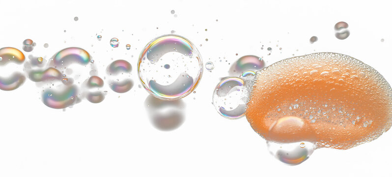 Iridescent bubbles float amongst a cluster, some with a textured orange mass