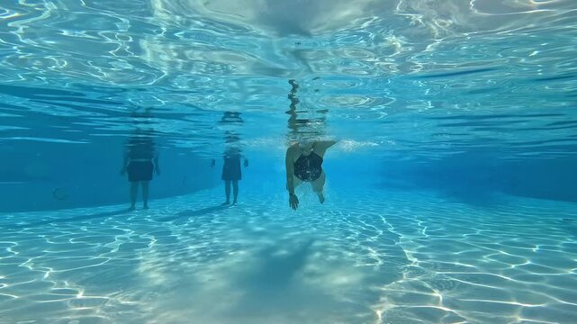 Underwater view of woman swimming in a pool
