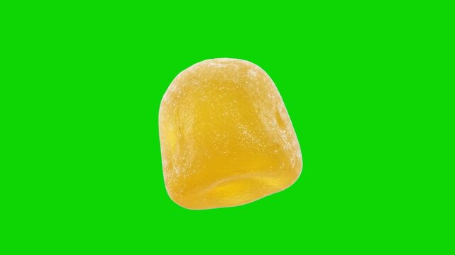 A macro, detailed view of a single bright yellow jelly candy, gummy dome, or jelly bean floating at an angle. Isolated against a vibrant chroma key green screen backdrop, this sweet confectionery asse