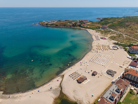 Aerial view of Nestinarka beach with rows of umbrellas, turquoise water, and coastal resorts in Burgas, Bulgaria.