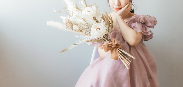 A bride in a wedding dress holding a bouquet of flowers.