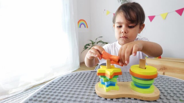 Kid playing with wood toys at preschool classroom. Kindergarten education games for children at nursery