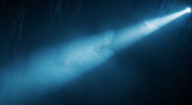 Cinematic wide shot of a deep blue light ray illuminating swirling eddies of smoke in a dark hazy cavernous environment