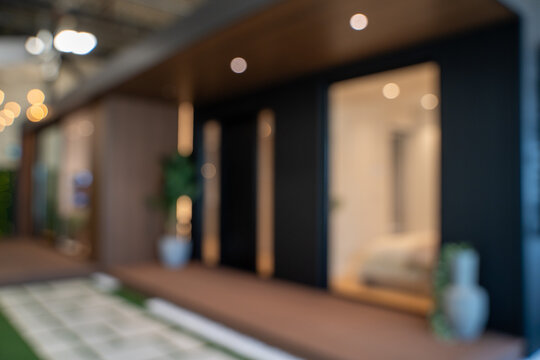 Blurred view of modern house exterior with illuminated windows.
