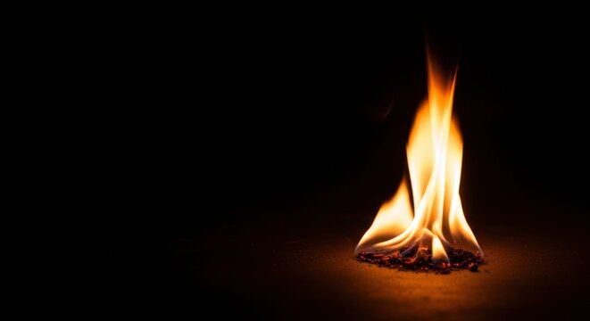 Small flame burning in darkness.