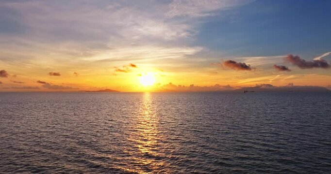 Spectacular sunrise over the calm ocean with golden sunlight reflection in Zhuhai, China