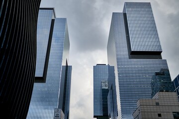 Fototapeta premium looking up at an angular modern building under cloudy sky