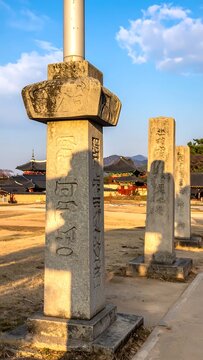 Ancient Korean stone pillars with carved Chinese characters at a historical temple site.