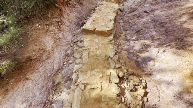Close-up of an eroded ochre and kaolin gully with pale purple white