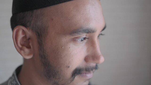 Man in traditional cap looks thoughtfully to the side