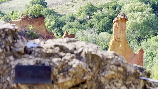 Ochre fairy chimney hoodoo of les Cheminees de Fee revealed behind