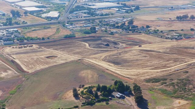 Panoramic aerial view over golden countryside and farmland toward the town of American Canyon, with tidal wetlands and San Pablo Bay on the horizon in Northern California summer light.