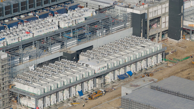 Khlong Tamru, Chon Buri, Thailand - 09 March 2026: Aerial view of Bridge Data Center construction site with rows of modular cooling units, steel framework, and heavy machinery.