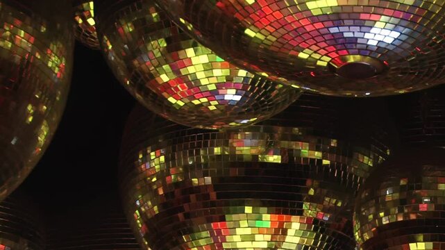 The party lights dance across sparkling disco balls, creating a vibrant kaleidoscope of color.