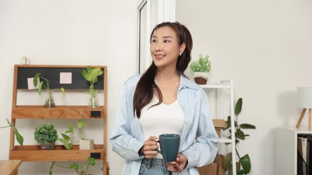 Ecommerce, packing, shipping, fulfillment, order small business owner talking on phone while holding coffee mug discussing shipment status and customer orders in warehouse workspace.