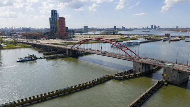 Amsterdam, Netherlands - 14 April 2026: Aerial view of Zuiderzeeweg bridge spanning the water with modern buildings and a river cruise ship in the background.