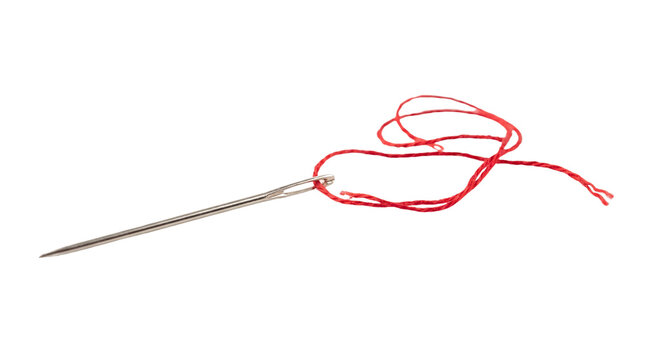 Sharp silver sewing needle threaded with a vibrant red string isolated on a white background