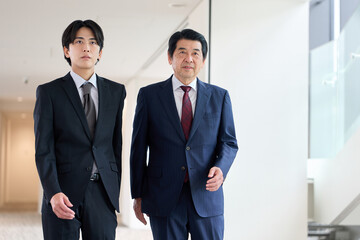 Fototapeta premium オフィス内を歩くアジア人ビジネスパーソン