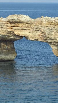 Vertical video of stone arch Kamara and rocks in Mediterranean sea on Crete, Greece. Zoom effect.