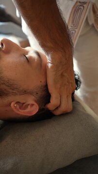 Relaxed man receiving a therapeutic head massage at a wellness spa
