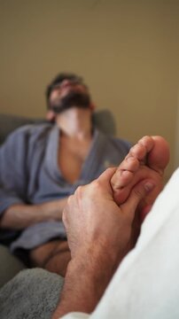 Relaxed man receiving a therapeutic foot massage at a wellness spa