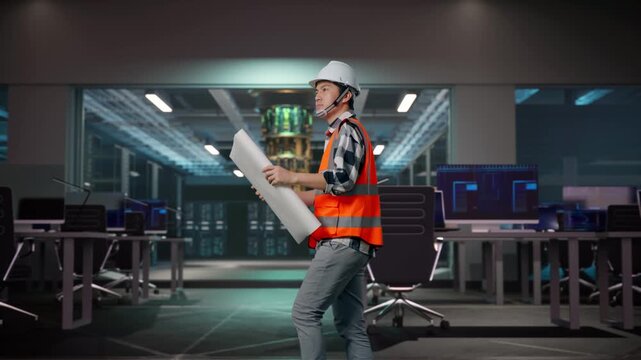 Side View of Asian Male Engineer Looking At Blueprint In His Hands While Walking at Futuristic Quantum Computer Data Center Control Room