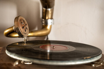 Detailed close-up of an antique gramophone needle resting on a vinyl record with shallow depth of field. © efiederphoto