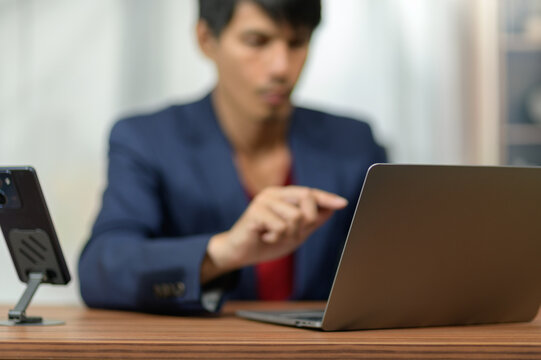 Businesswoman Using Laptop and Smartphone at Office Desk in Professional Environment