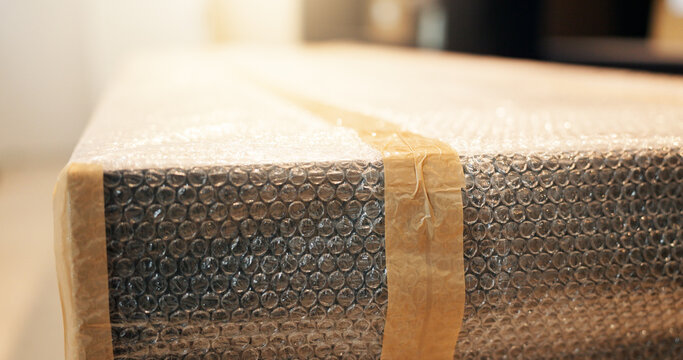 Box, packaging and stock with bubble wrap for ecommerce, inventory and shipping preparation. Parcel, tape or fragile item for damage prevention, package dispatch and plastic safeguarding for delivery