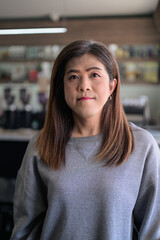 Fototapeta premium Portrait of a Thai Transgender Woman Looking at Camera Standing Indoors