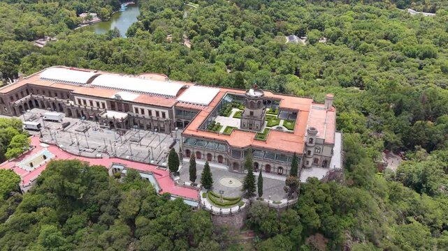 Aerial view of Chapultepec Castle and Mexico City skyline. Drone shot of historic castle, lush green park and skyscrapers on Paseo de la Reforma in CDMX.