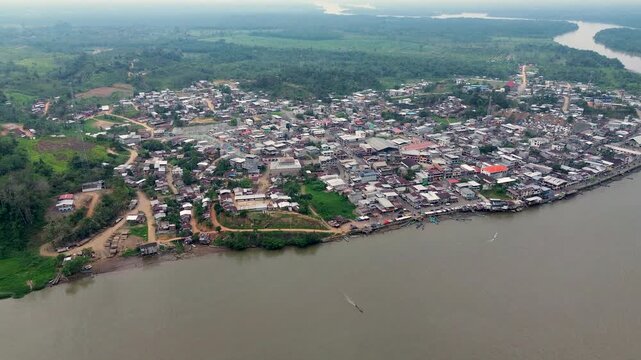 Wide Drone View of Amazon River Town in Ecuador with Dense Settlement, Brown Water, Forested Banks and Remote Tropical Community Landscape