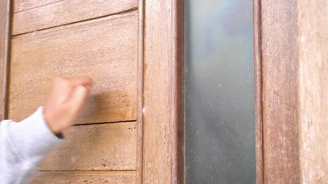 Someone's hand knocked on the wooden door several times to come in