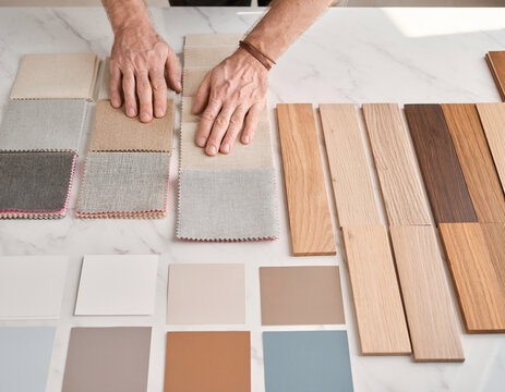 Interior Designer Hands Arranging Material Samples on Marble Table Flat Lay