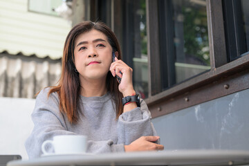 Fototapeta premium Portrait of a Thai Transgender Woman Answering Phone Call Sitting Outside