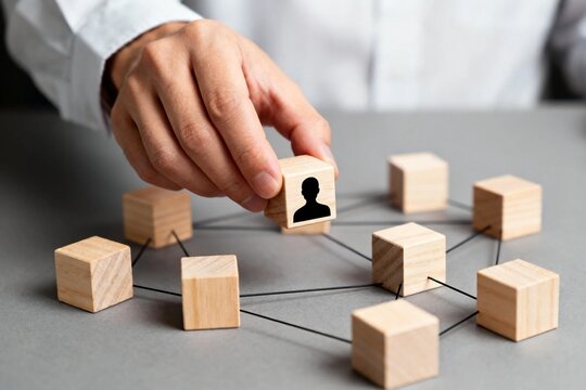 Hand placing human icon on networked wooden blocks