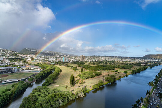 Rainbow is an optical phenomenon caused by refraction.  City of Honolulu, Oahu island, Hawaii.  Ala Wai Golf Course with Ala Wai Canal