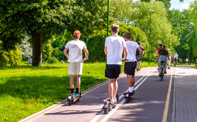 A guy rides an electric scooter in the summer Park  © licvin