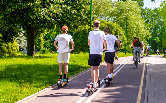 A guy rides an electric scooter in the summer Park
