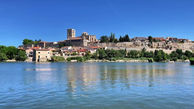 Historic medieval city skyline reflected in calm river under clear blue sky, City of Zamora in Spain