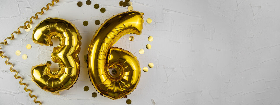 Yellow Gold foil balloon number thirty-six on a concrete background. Birthday card with lettering 36. Anniversary concept. For anniversary, birthday, wedding event, new year celebration.