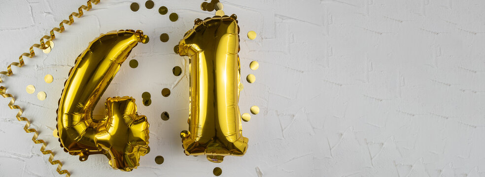 Yellow Gold foil balloon number forty-one on a concrete background. Birthday card with lettering 41. Anniversary concept. For anniversary, birthday, wedding event, new year celebration.
