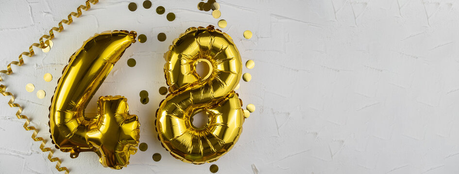 Yellow Gold foil balloon number forty-eight on a concrete background. Birthday card with lettering 48. Anniversary concept. For anniversary, birthday, wedding event, new year celebration.