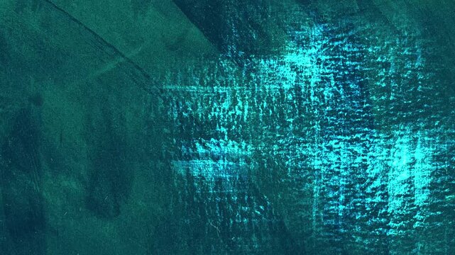 Animated abstract grunge background in turquoise tones. Looped texture with scratches, paint strokes and scuffs.