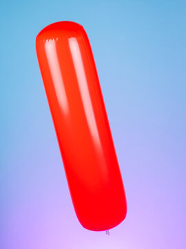 Close-up of an inflatable stick on a purple background, highlighting its simple and vibrant design. Perfect for fun and summertime play.