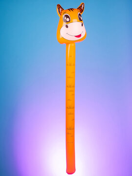 Close-up of an inflatable stick with a cow-shaped inflatable head on a purple background, showcasing its playful and whimsical design