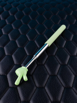 Close-up of a metallic pointer in the shape of a hand with the index finger on a black background