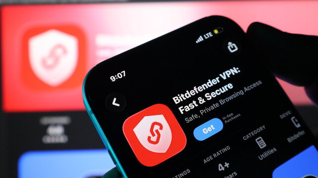 Smartphone held in hand displaying mobile application store page for bitdefender vpn app.