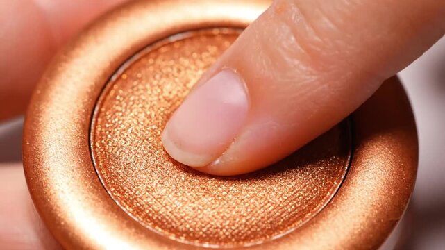 Close up of shimmery bronze eyeshadow in a round compact